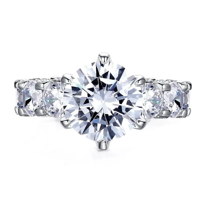 The  Luxury Ring with Multiple Moissanites from  Azzurie is as bright as a diamond.  Descrição e Detalhes This ring se destaca como uma verdadeira obra-prima da joalheria, sua gema central irradiando brilho e qualidade excepcionais, enquanto o arranjo delicado de pedras menores ao redor eleva e realça ainda mais sua beleza geral. Especificações: Material: Banhado a prata Pedra: Moissanite Hipoalergênico GRA Certificate inclued.